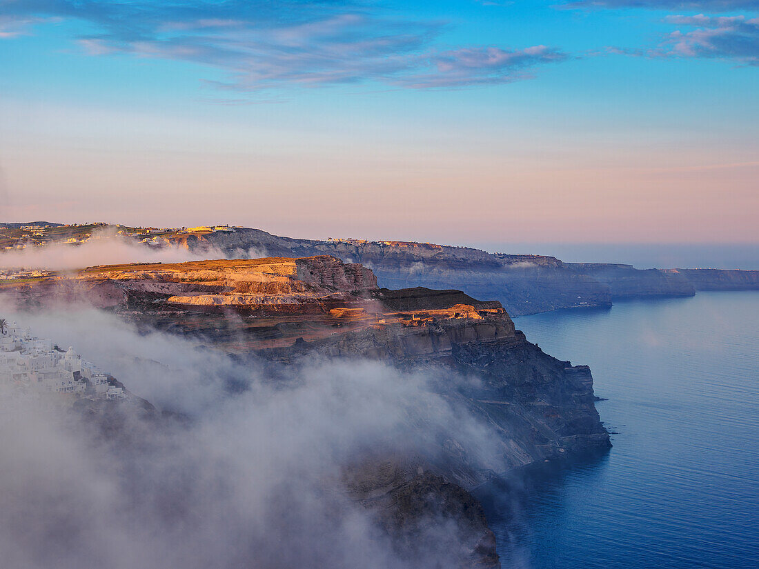 Caldera und Stadt Fira bei nebligem Sonnenaufgang, Insel Santorin (Thira), Kykladen, Griechische Inseln, Griechenland, Europa