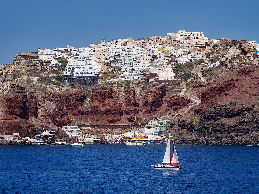 Sailboat in the caldera and Oia Village, Santorini (Thira) Island, Cyclades, Greek Islands, Greece, Europe