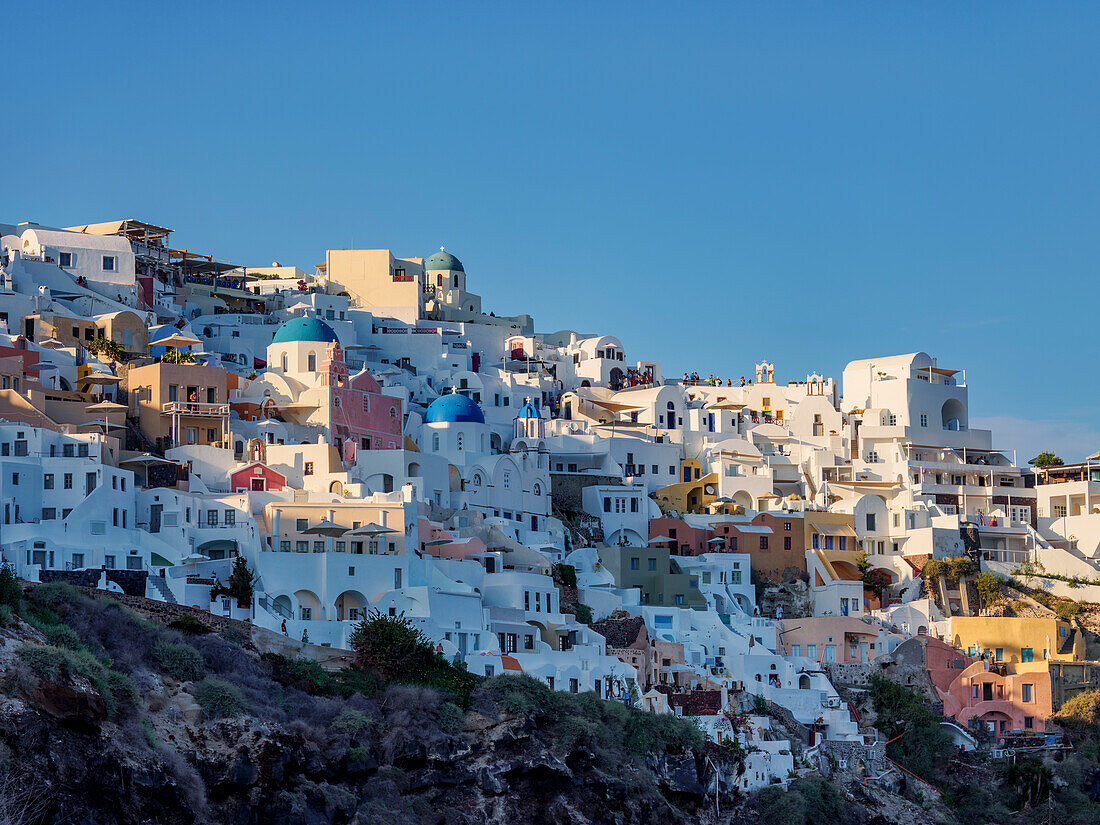 Blick auf die blauen Kuppelkirchen der Auferstehung des Herrn und des Heiligen Spyridon bei Sonnenuntergang, Dorf Oia, Insel Santorin (Thira), Kykladen, Griechische Inseln, Griechenland, Europa