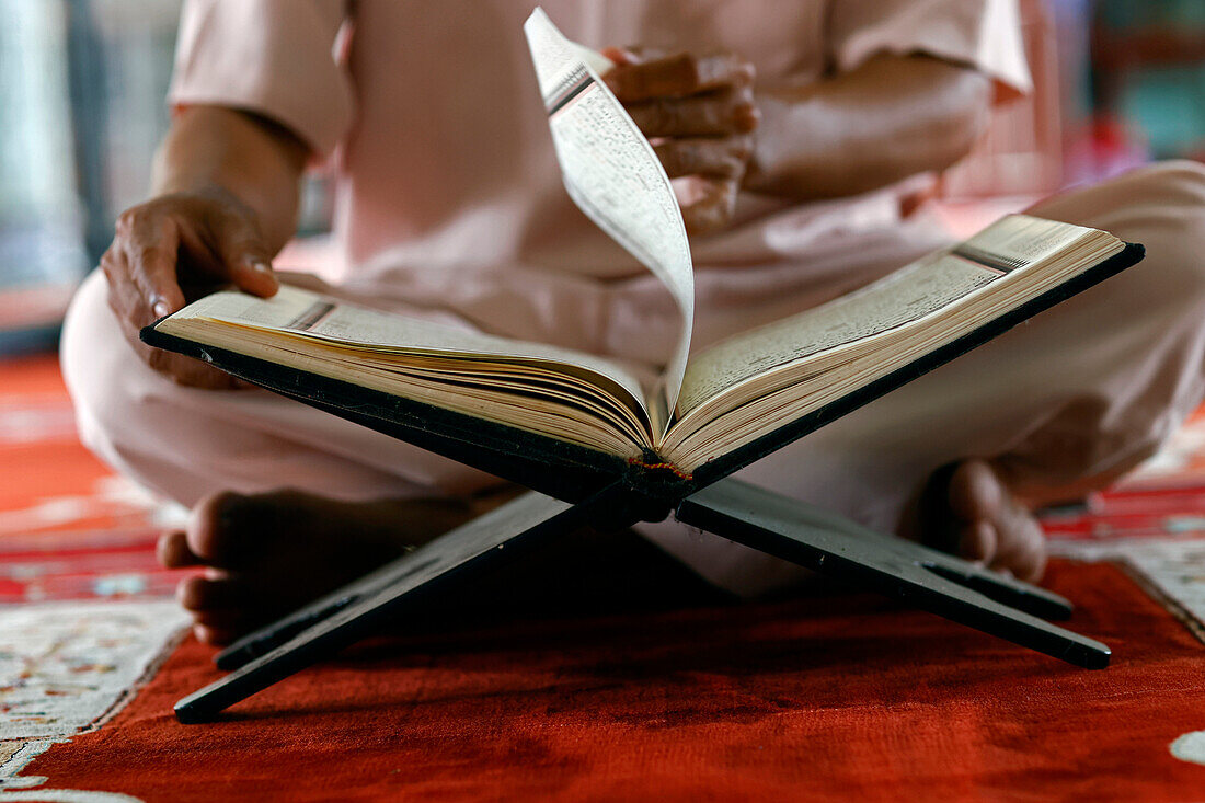 Muslim man sitting reading the Quran (Koran) the holy book of Islam, Mubarak Mosque, Chau Doc, Vietnam, Indochina, Southeast Asia, Asia