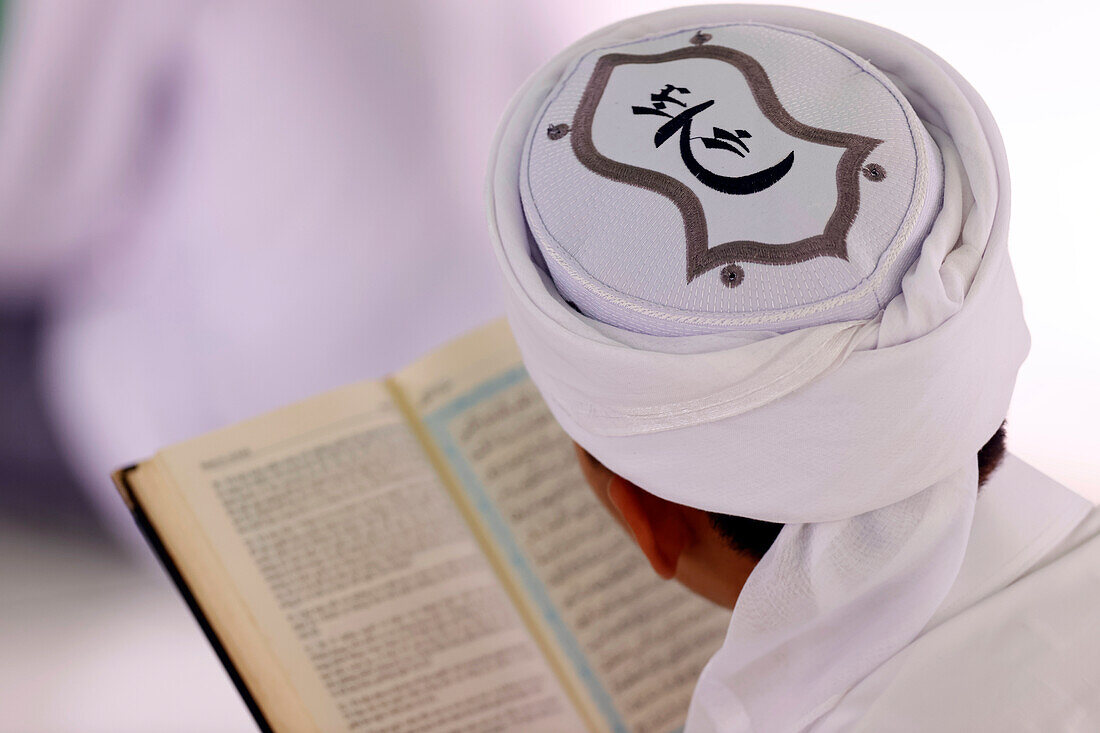 Muslim man reading an Arabic Holy Quran (Koran), Jamiul Azhar mosque, Vietnam, Indochina, Southeast Asia, Asia