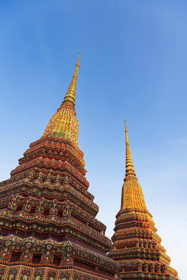 Close-up of ornate temple structures (stupa) lit at sunset at the Buddhist temple complex of Wat Pho (Temple of the Reclining Buddha), Bangkok, Thailand, Southeast Asia, Asia