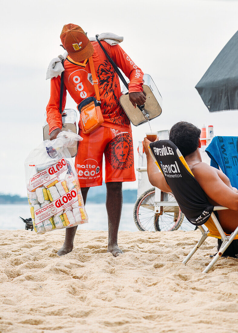 Junger Mann verkauft einen speziellen Tee namens Mate am Strand von Leblon in Rio de Janeiro, Brasilien, Südamerika