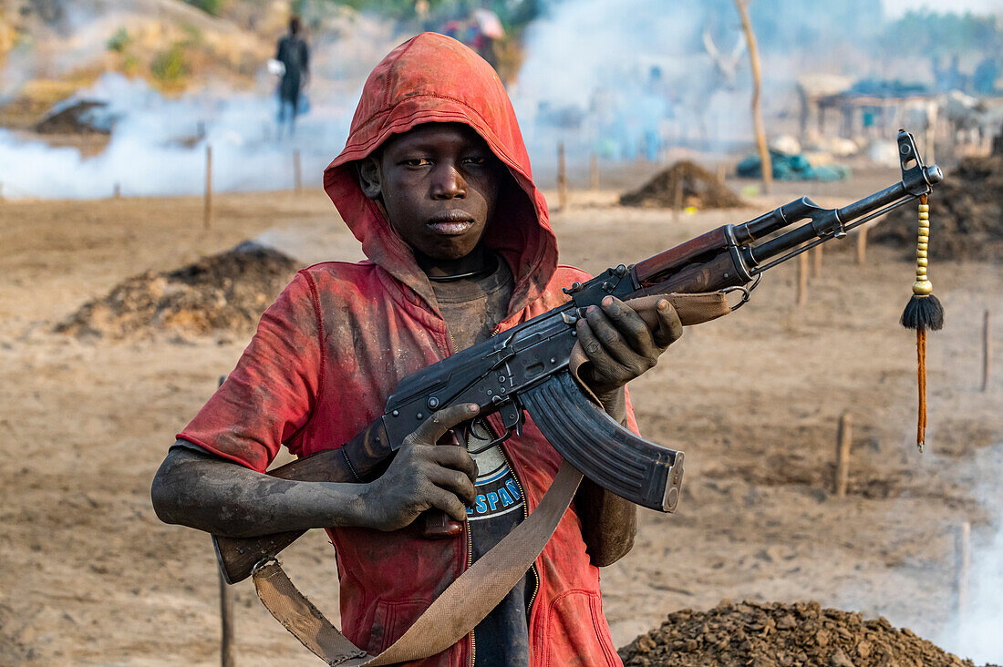 Young boy posing with Kalashnikov, Mundari tribe, South Sudan, Africa