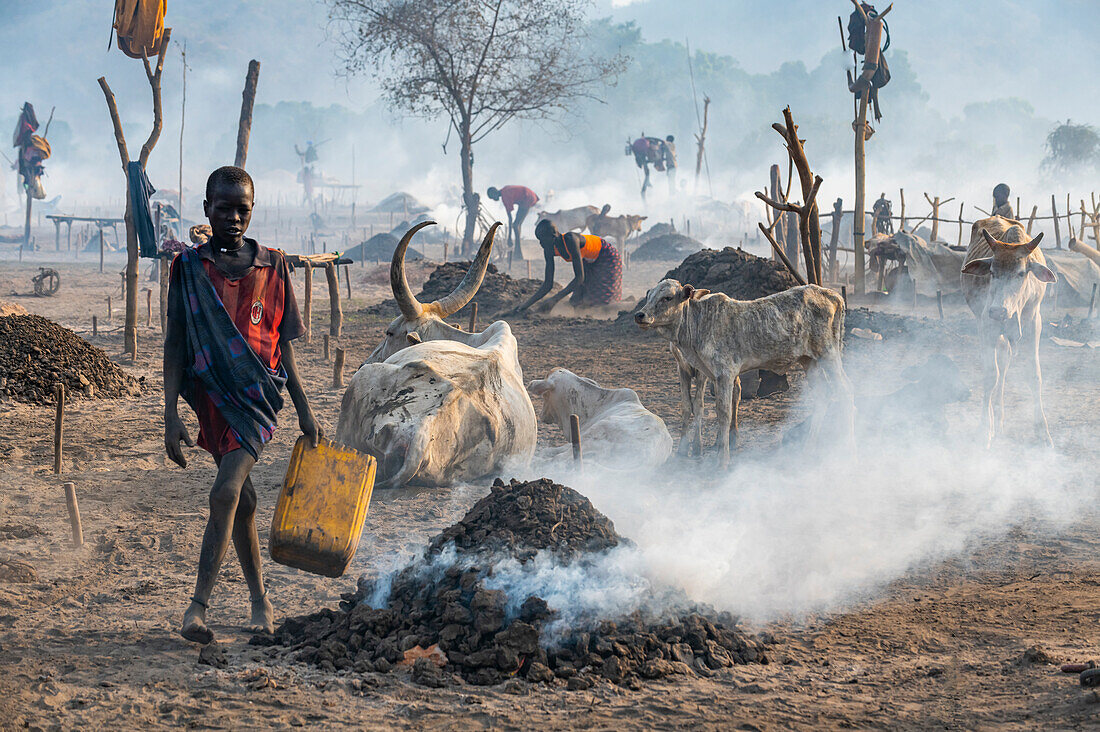 Junger Junge sammelt Kuhdung, Stamm der Mundari, Südsudan, Afrika