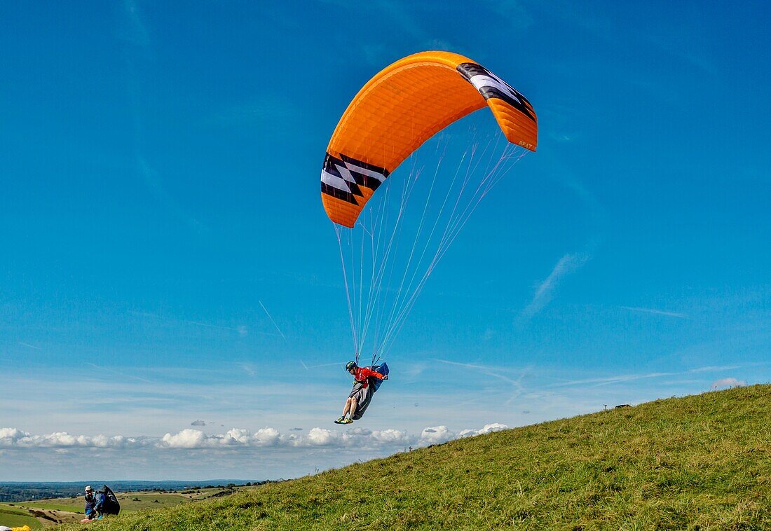 Gleitschirmflieger beim Start am Mount Caburn, nahe Lewes, East Sussex, England, Vereinigtes Königreich, Europa