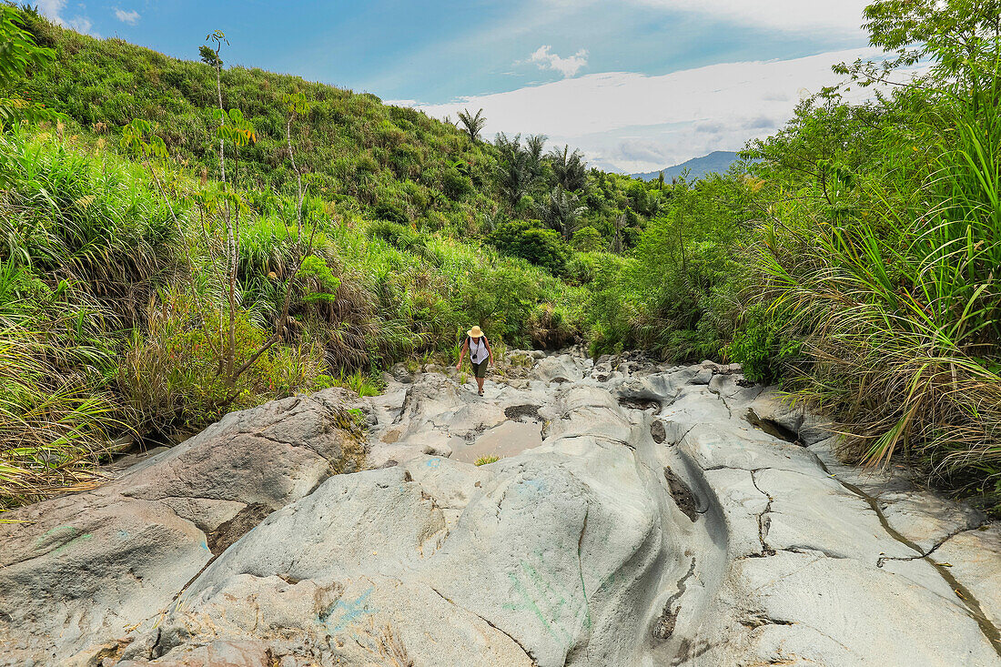 Wanderer auf einem alten Lavastrom, jetzt ein glattes erodiertes Flussbett und Wanderweg zum Vulkan Lokon, nahe Tomohon Stadt, Gunung Lokon, Tomohon, Nordsulawesi, Indonesien, Südostasien, Asien