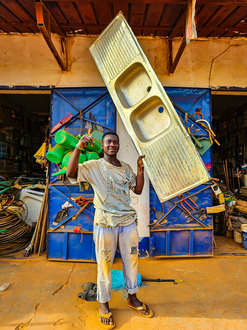 Man holding an entire sink, Wau, Western Bahr el Ghazal, South Sudan,