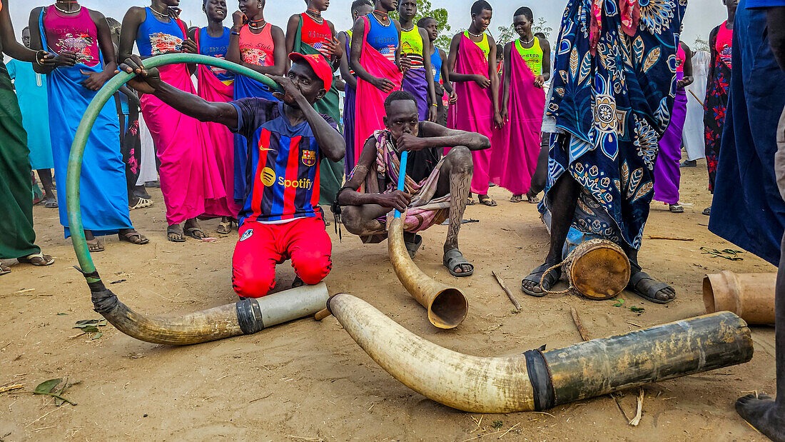 Männer musizieren mit Kuhhörnern auf einer traditionellen Dinka-Hochzeit, Bor, Zentralregion, Südsudan, Afrika