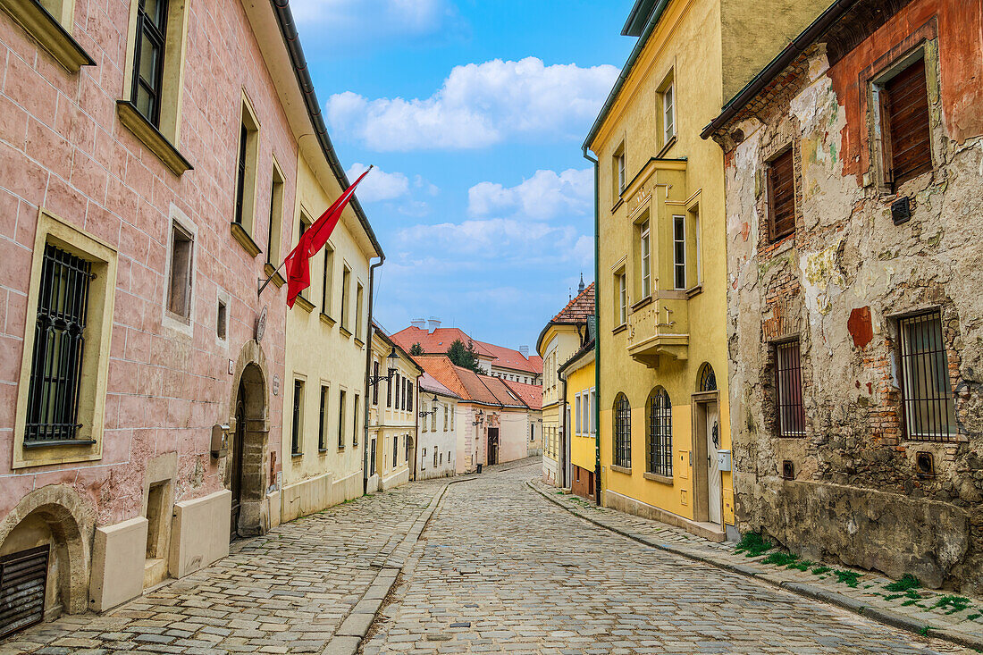 Historische Flachbauten mit traditioneller Architektur rund um eine Kopfsteinpflasterstraße in der Altstadt von Bratislava, Slowakei, Europa