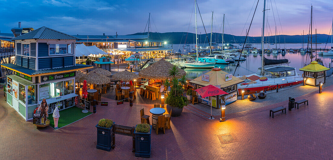 Blick auf Boote und Restaurants an der Knysna Waterfront in der Abenddämmerung, Knysna, Garden Route, Western Cape, Südafrika, Afrika