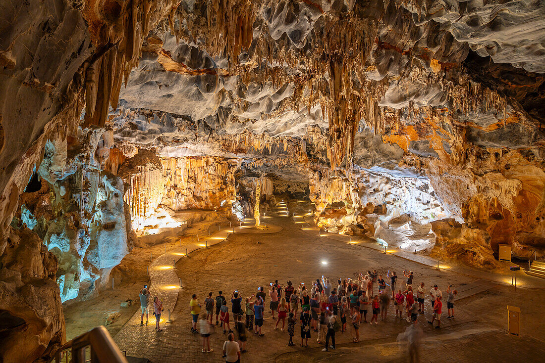 Blick auf Besucher, die Stalagmiten und Stalaktiten im Inneren der Cango-Höhlen betrachten, Oudtshoorn, Westkap, Südafrika, Afrika