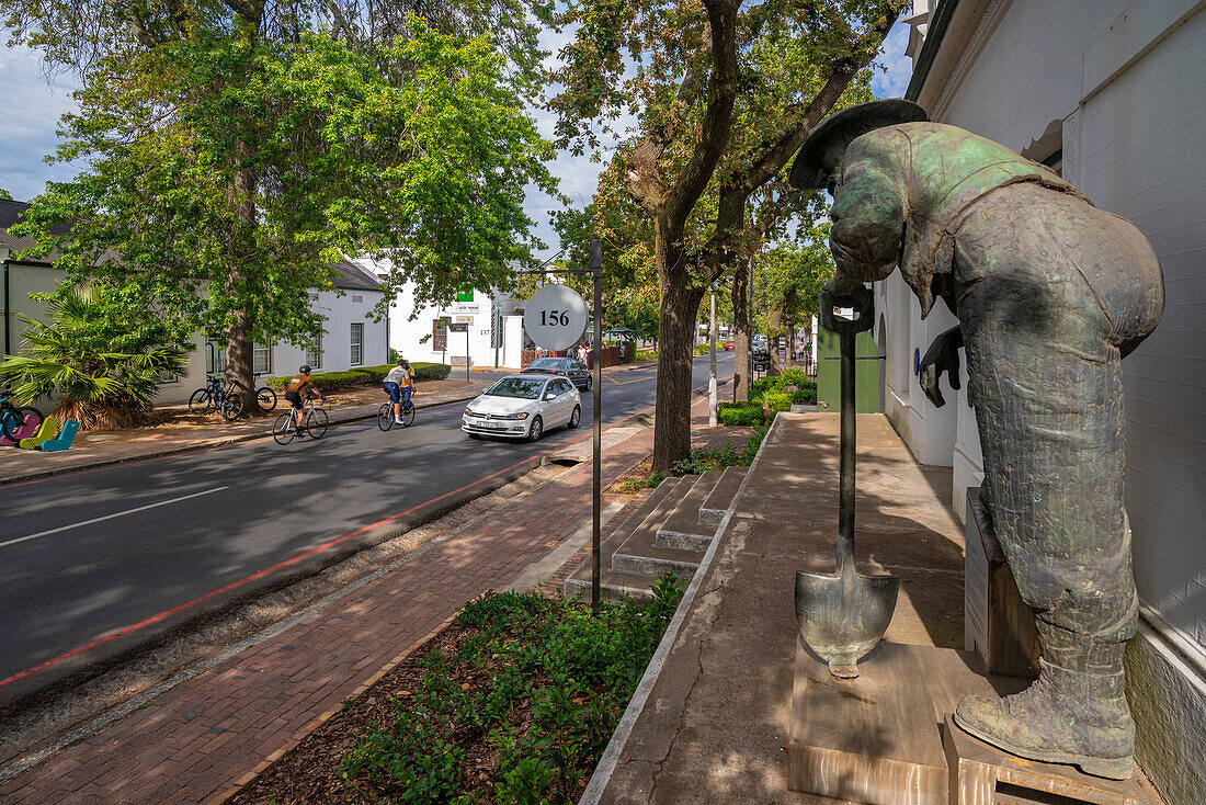 Blick auf die Old-Mac-Statue und Radfahrer auf der Straße, Stellenbosch Central, Stellenbosch, Western Cape, Südafrika, Afrika