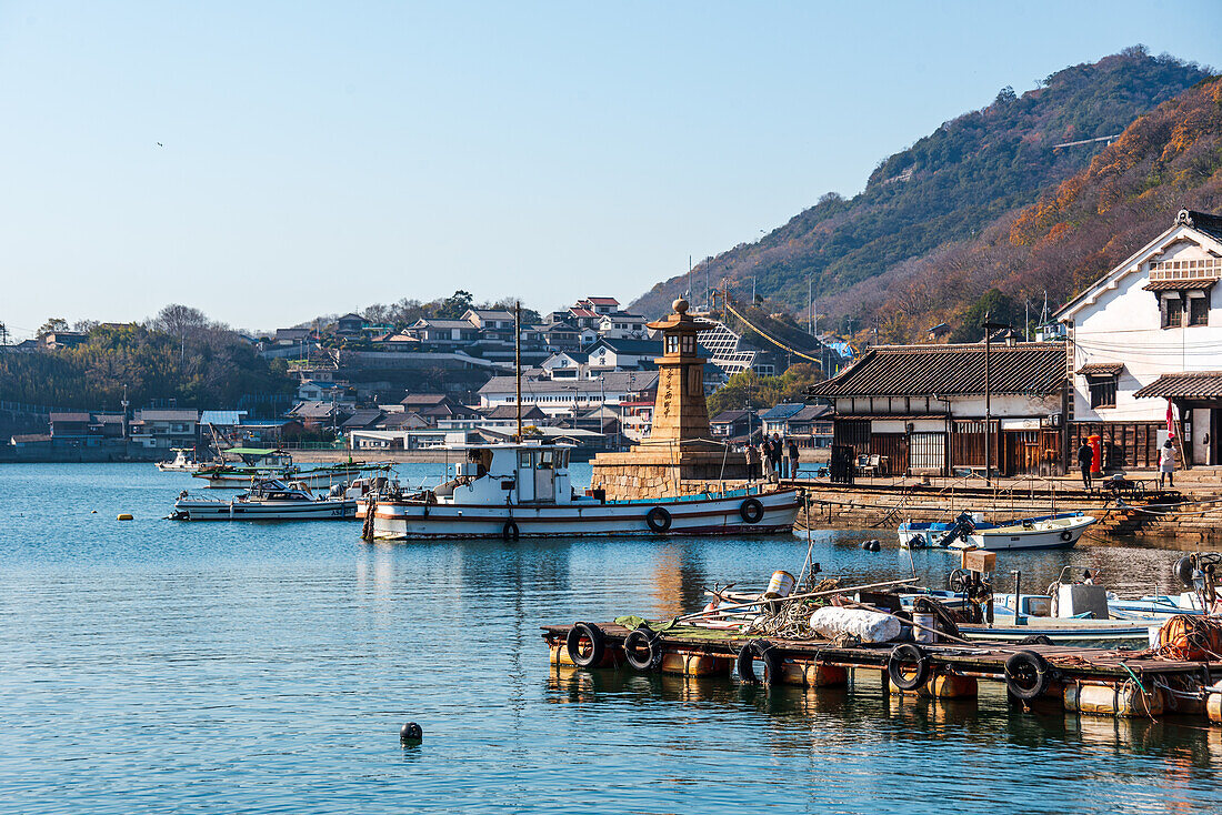 Blick auf den kleinen Fischerhafen von Tomonoura mit dem berühmten steinernen Leuchtturm und dem blauen Wasser, Tomonoura, Honshu, Japan, Asien