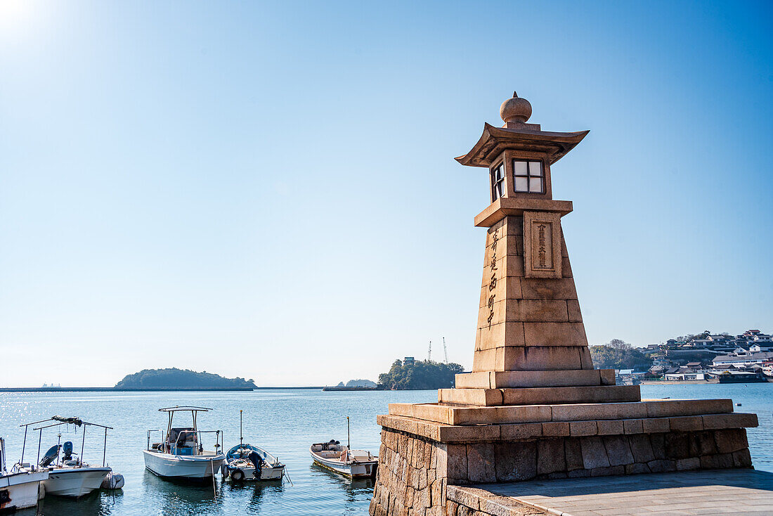 Schöner japanischer Leuchtturm im Laternenstil am blauen Meer in Tomonoura, Honshu, Japan, Asien