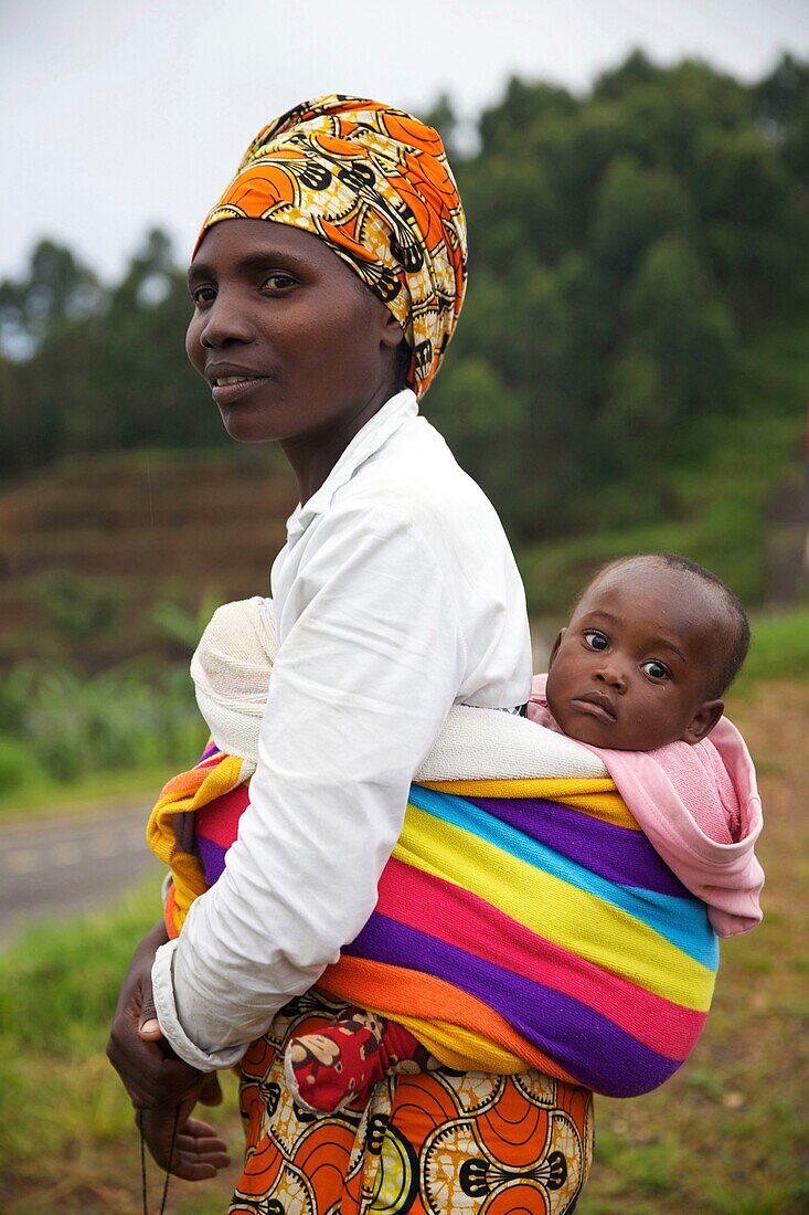 Rwanda, Gisakura, woman wearing a colorful turban and carrying her baby in the back