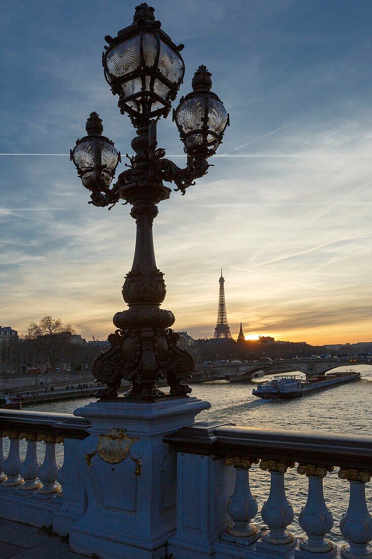 Frankreich, Paris, von der UNESCO zum Weltkulturerbe erklärtes Gebiet, die Putten, die eine Straßenlaterne von Henri Gauquie auf der Pont Alexandre III (Brücke Alexandre der Dritte) tragen, und der Eiffelturm im Hintergrund