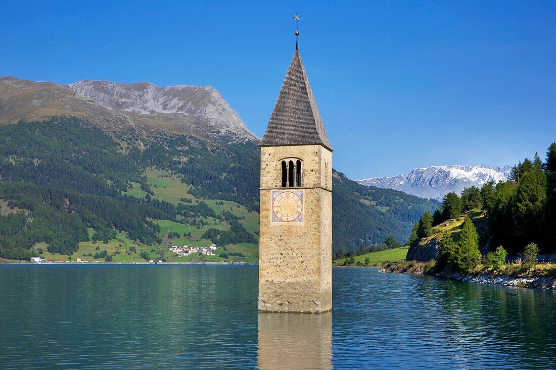 Italien, autonome Provinz Bozen, Reschensee, verschlungener Kirchturm, der aus dem Wasser des Sees auftaucht, umgeben von üppig bewachsenen Bergen