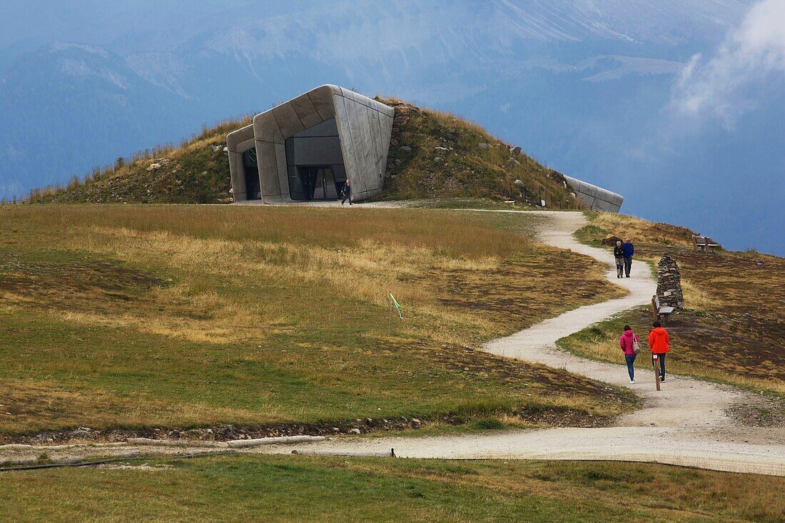 Italien, autonome Provinz Bozen, Pustertal, Wanderer auf einem Weg, der zum Messner Mountain Museum führt, einem futuristischen, von Zaha Hadid entworfenen Museum, das auf einem Berggipfel thront und dem Bergsteiger und Alpinisten Reinhold Messner gewidmet ist