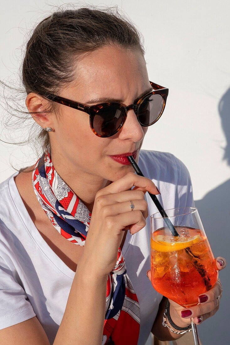 Italy, Campania, Naples area, Pozzuoli, young Italian woman drinking a spritz