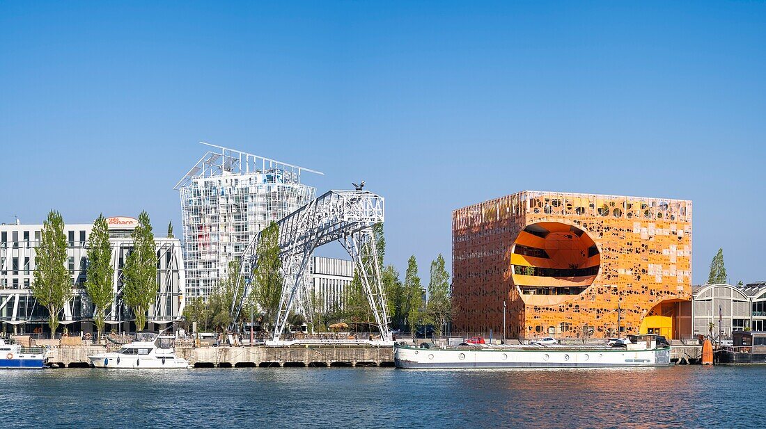 France, Rhône (69), Lyon, le quartier de La Confluence au sud de la Presqu'île, proche de la confluence du Rhône et de la Saône, le quai Rambaud le long des anciens docks, le Pavillon des Salins aussi appelé le Cube Orange des architectes Dominique Jakob et Brendan Mac Farlane et l'immeuble résidentiel Ycone de l'architecte Jean Nouvel