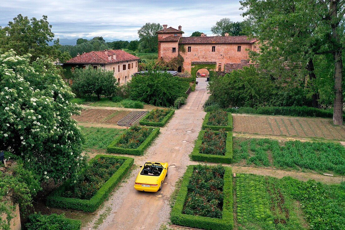 Italien, Emilia Romagna, Polesine Zibello bei Parma, Antica Corte Pallavicina Hotel und Restaurant, Alfa Romeo Duetto Spider gelbes Cabriolet (Luftaufnahme)