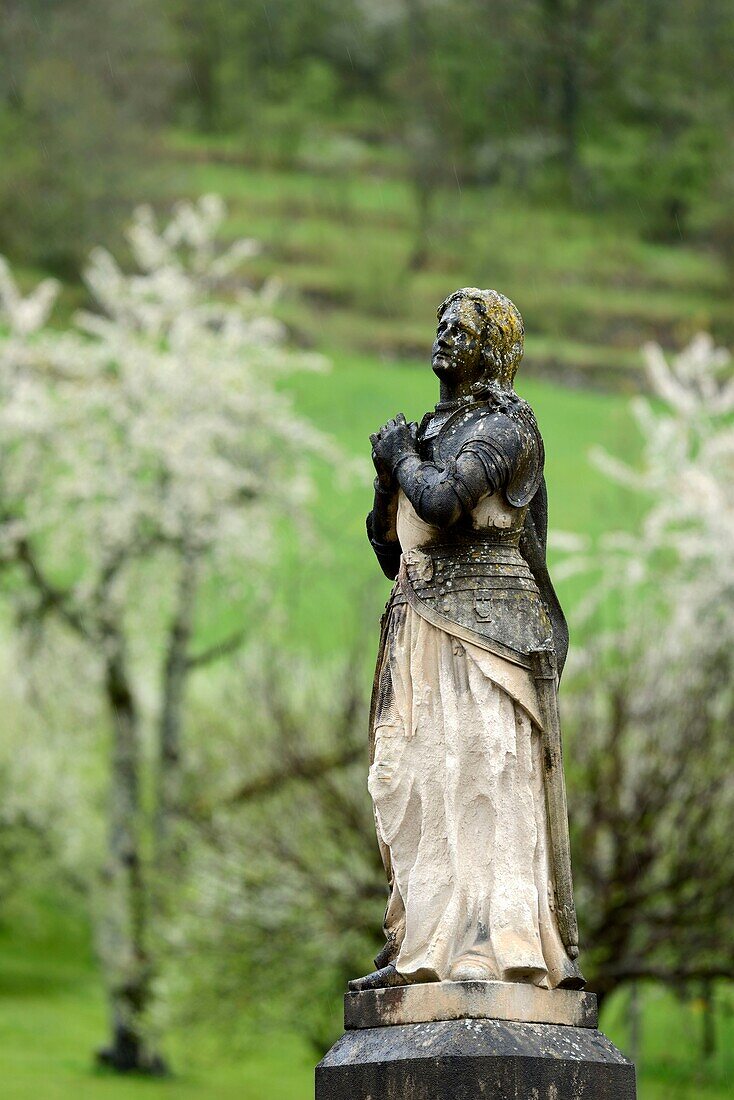 France, Doubs, Mouthier Haute Pierre, parvis, Saint Laurent church dated 15th century, Jeanne d Arc statue, orchards, cherry blossoms in april