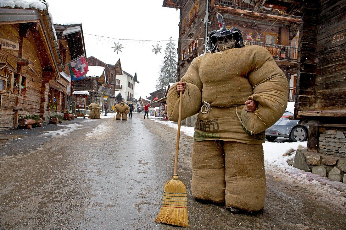 Schweiz, Kanton Wallis, Val d'Herens, Dorf Evolene, Karneval, Vorbereitung der Empailles (junge Männer, die mit alten Säcken gekleidet sind, die mit ca. 50 kg Stroh gestopft sind) und eine lokal geschnitzte Holzmaske tragen, die mythische und oft furchterregende Tiere darstellt