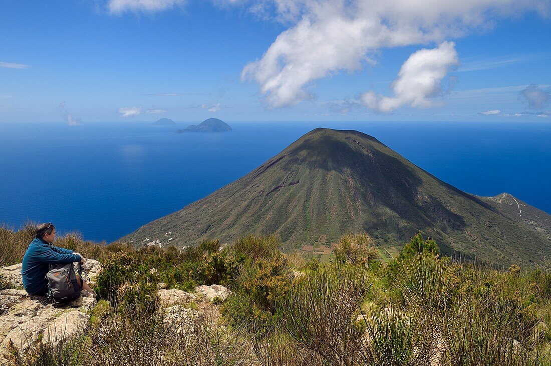 Italien, Sizilien, Äolische Inseln, von der UNESCO zum Weltnaturerbe erklärt, Insel Salina, Wanderer auf dem Gipfel des alten Vulkans Monte Fossa delle Felci mit Blick auf den Zwillingsvulkan Monte dei Porri, im Hintergrund die Inseln Filicudi und Alicudi