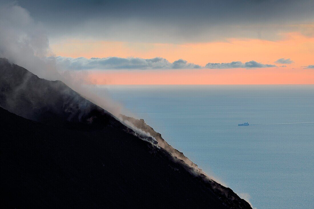 Italien, Sizilien, Äolische Inseln, von der UNESCO zum Weltnaturerbe erklärt, Insel Stromboli, Fumarolen und Wolken an den Hängen des aktiven Vulkans bei Sonnenuntergang