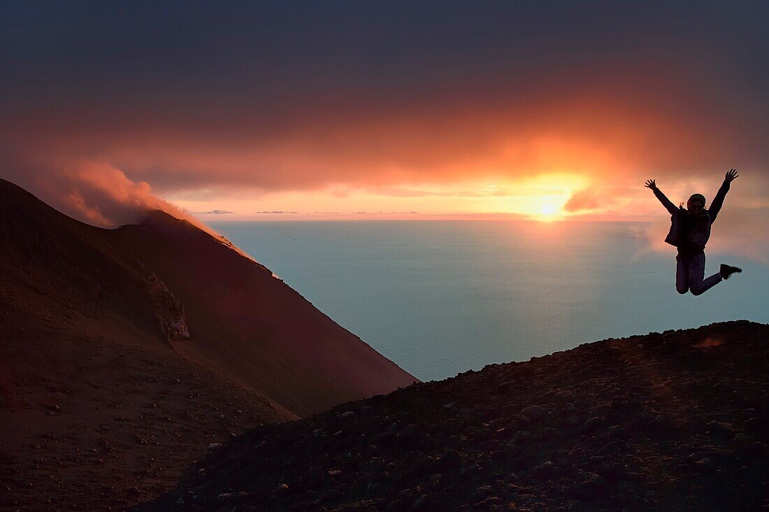 Italien, Sizilien, Äolische Inseln, von der UNESCO zum Weltkulturerbe erklärt, Insel Stromboli, Wanderer und Fumarolen eines Ausbruchs an den Hängen des aktiven Vulkans bei Sonnenuntergang