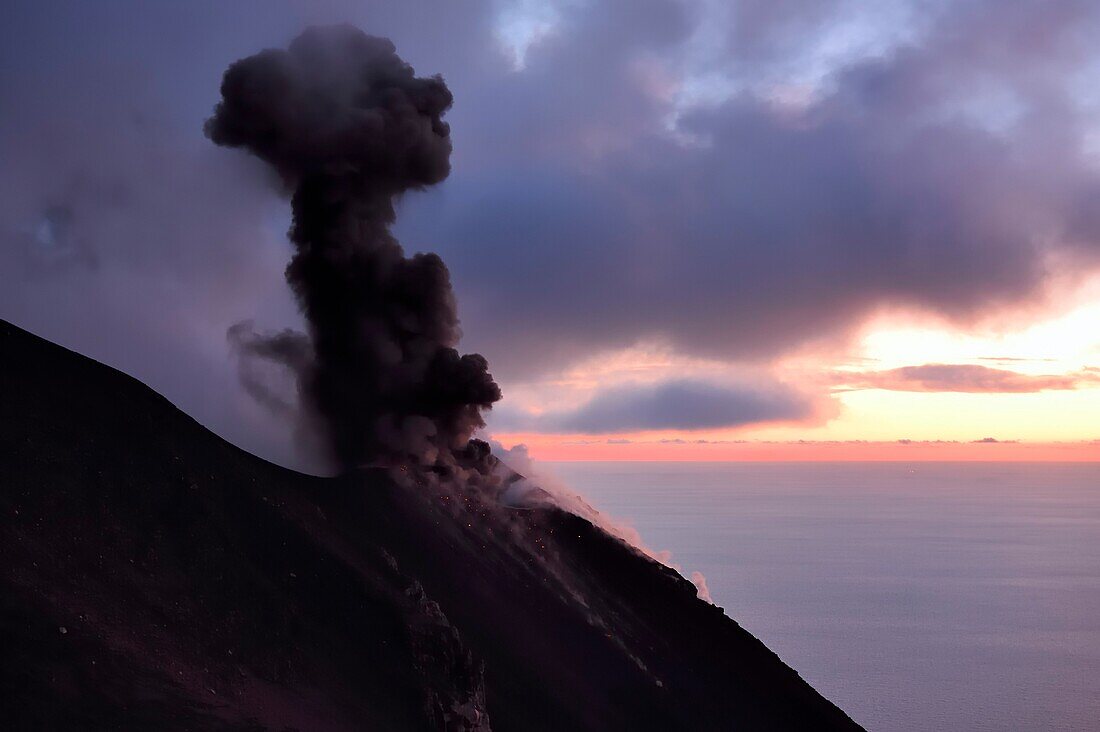 Italien, Sizilien, Äolische Inseln, von der UNESCO zum Weltnaturerbe erklärt, Insel Stromboli, Ausbruch und Projektion von Lavabomben an den Hängen des aktiven Vulkans bei Sonnenuntergang