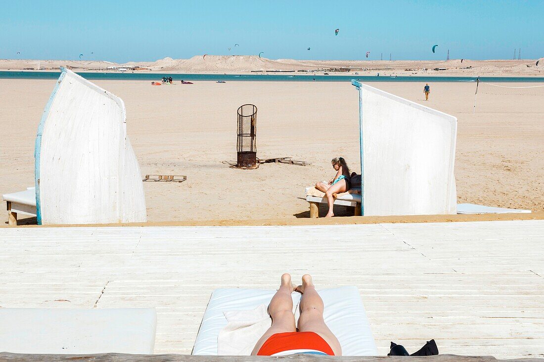 Marocco, Oued Ed-Dahab, Dakhla, Ocean Vagabond Resort, guests of a luxury eco-lodge sitting on a beach lounge in the sun