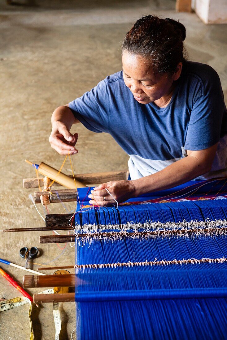 Indonesia, Sulawesi island, Toraja country, Tana Toraja, Rantepao area, Sadan Tobarana, weaving woman in a traditional Toraja house