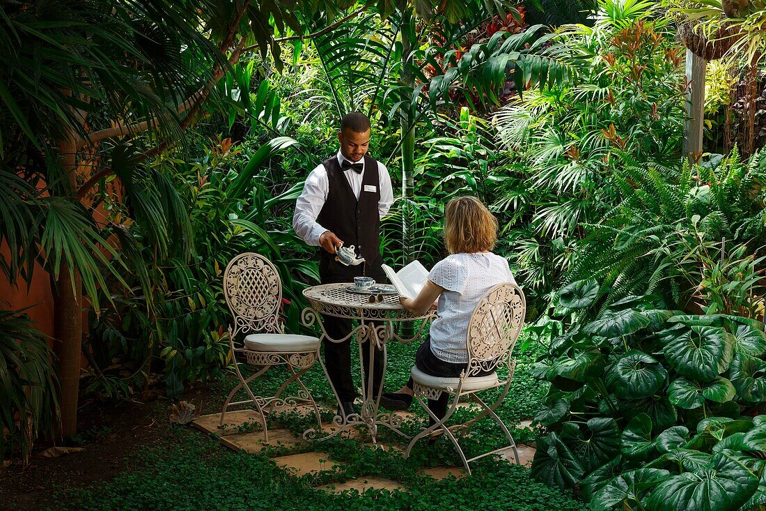 Spain, Canary Islands, La Palma, Tea service by a staff member, in the garden of a tropical luxury hotel