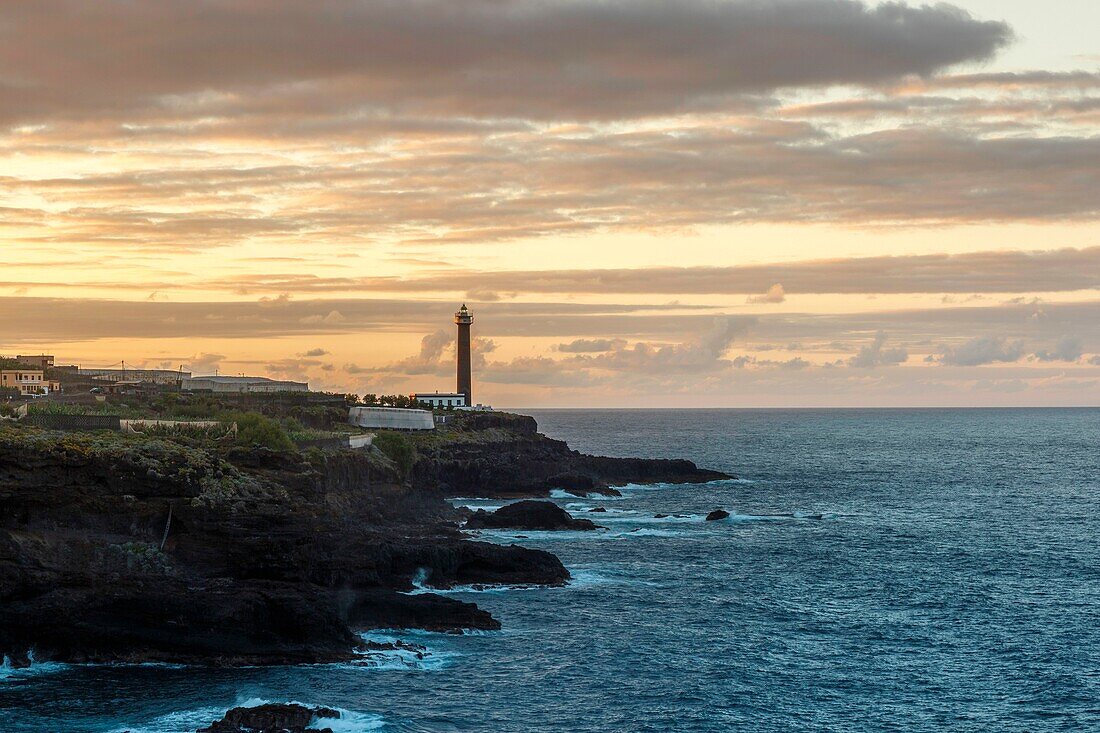 Spain, Canary Islands, La Palma, view of a lighthouse against the light by the sea at sunset