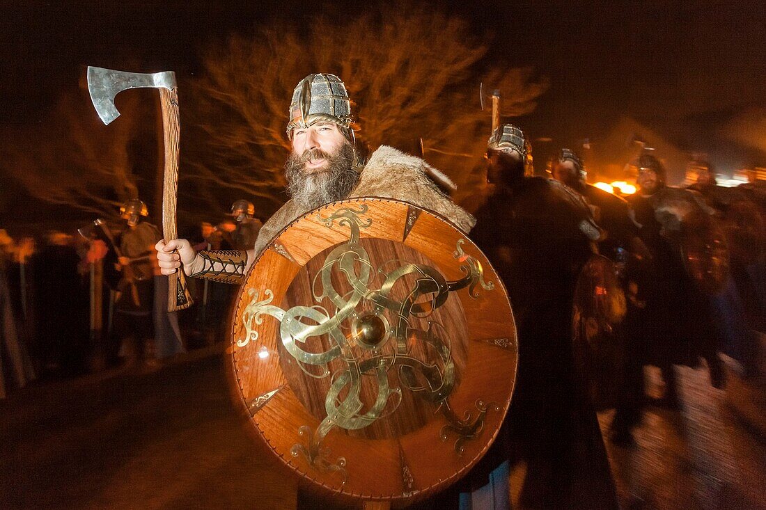 Vereinigtes Königreich, Schottland, Shetlandinseln, Festland, Lerwick, Up Helly Aa Festival, eine Gruppe von Guizern zieht zum Platz, wo das Wikinger-Langschiff in Brand gesetzt wird