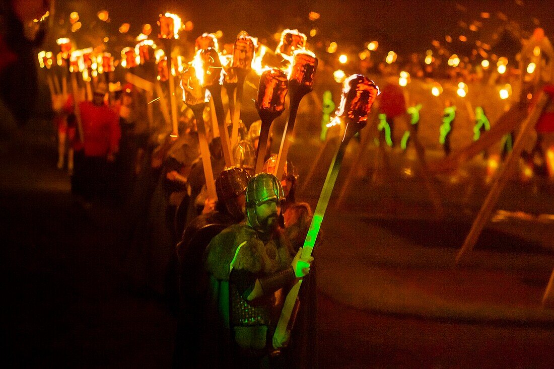 Vereinigtes Königreich, Schottland, Shetlandinseln, Festland, Lerwick, Up Helly Aa Festival, eine Gruppe von Guizern zieht zum Platz, wo das Wikinger-Langschiff in Brand gesetzt wird