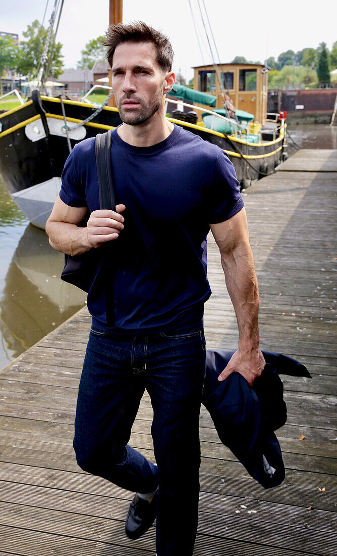 Man in jeans and blue shirt on wooden plank