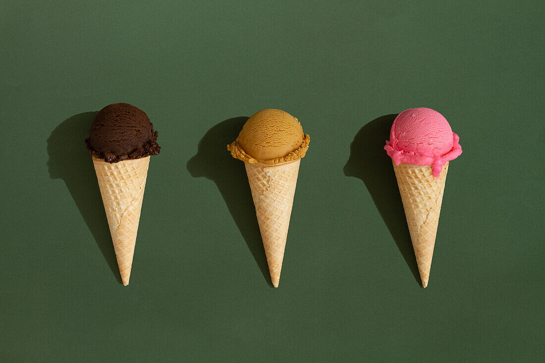 Colorful Assortment of Ice Cream Cones on Green Background