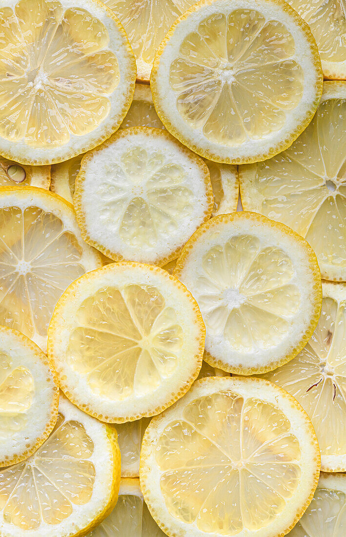 Top view of slices of ripe lemons artfully arranged, showcasing their fresh and tangy citrus appeal, perfect for culinary and nutritional themes.