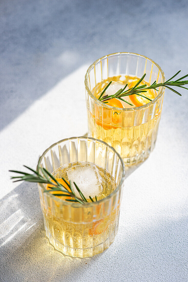 From above summer cocktail vodka with tonic and ripe kumquat fruit slices in the glass on stone table