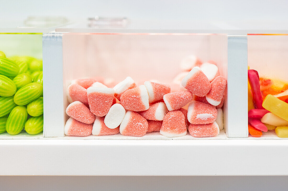 Assorted candy in clear dispensers, featuring watermelon slices at center stage