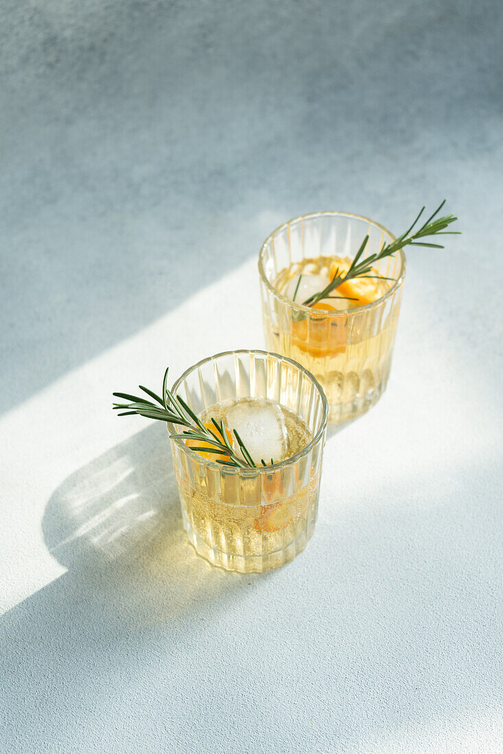 Sommercocktail Wodka mit Tonic und reifen Kumquat-Fruchtscheiben im Glas auf Steintisch von oben