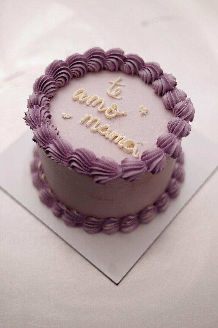 A beautifully decorated cake featuring lavender icing and stylish piping, perfect for celebrations and cooking demonstrations