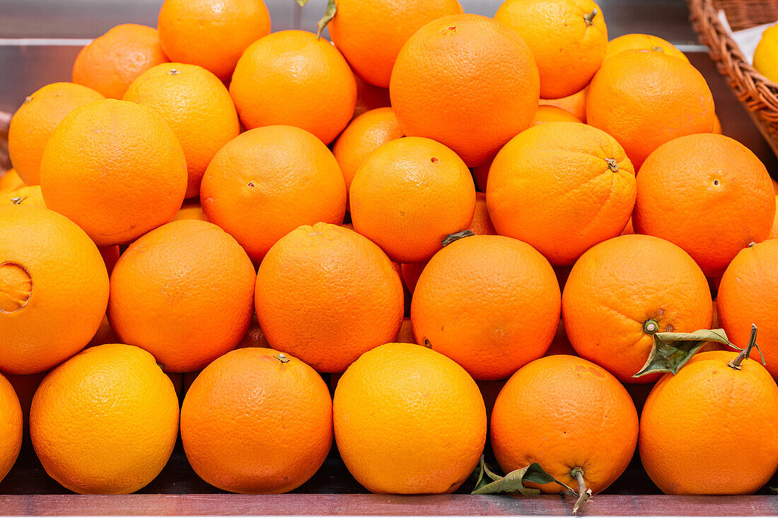 Eine lebhafte Auslage reifer Orangen, die an einem Marktstand ordentlich arrangiert sind und ihre Saftigkeit und Frische zur Schau stellen