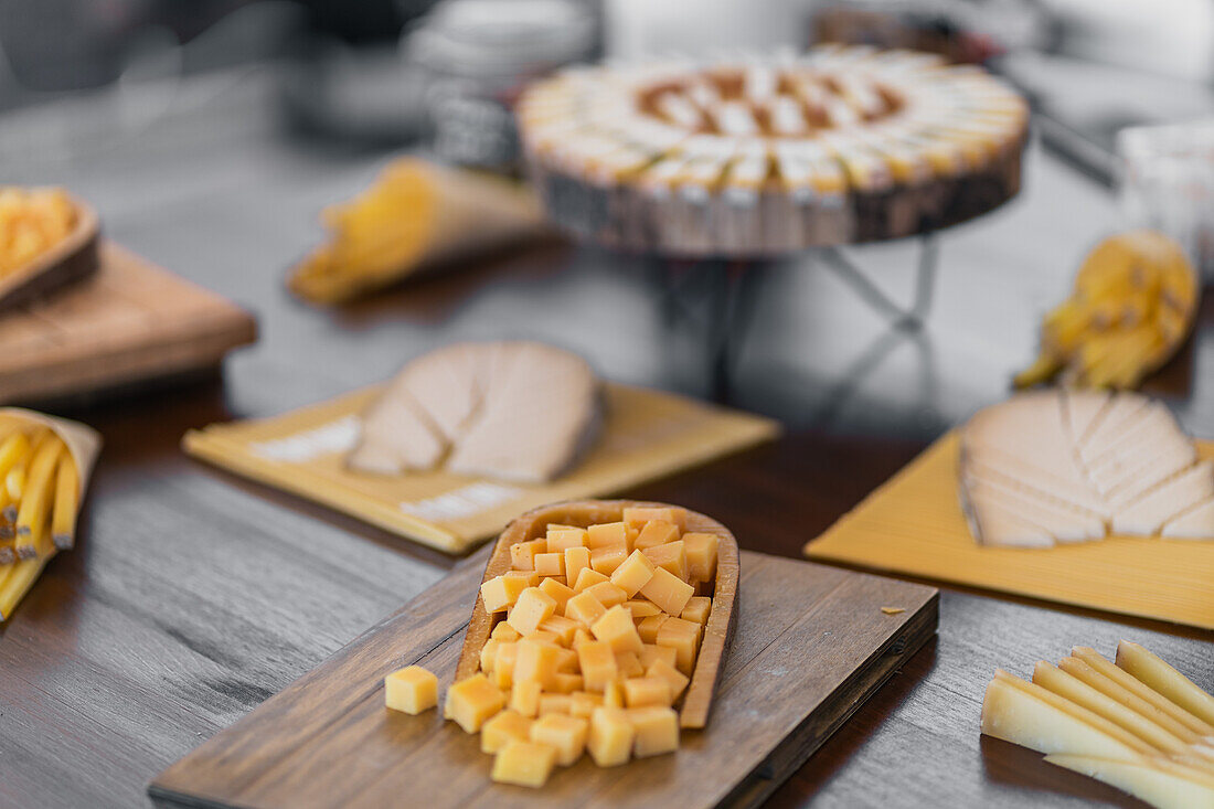 An array of gourmet cheeses artistically arranged on rustic wooden boards, perfect for a sophisticated bridal shower or wedding reception