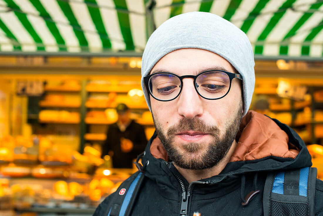 Tilburg, Netherlands. Former Syrian refugee visiting a Dutch market cheese stall at the weekly saturday market as part of his integration process.