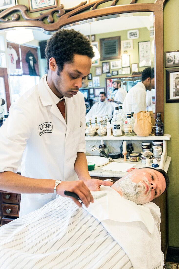 Professional Barber & Haircutter Shaving his Customer inside Schorem Barber Shop at Nieuwe Binnenweg, Rotterdam, Netherlands.