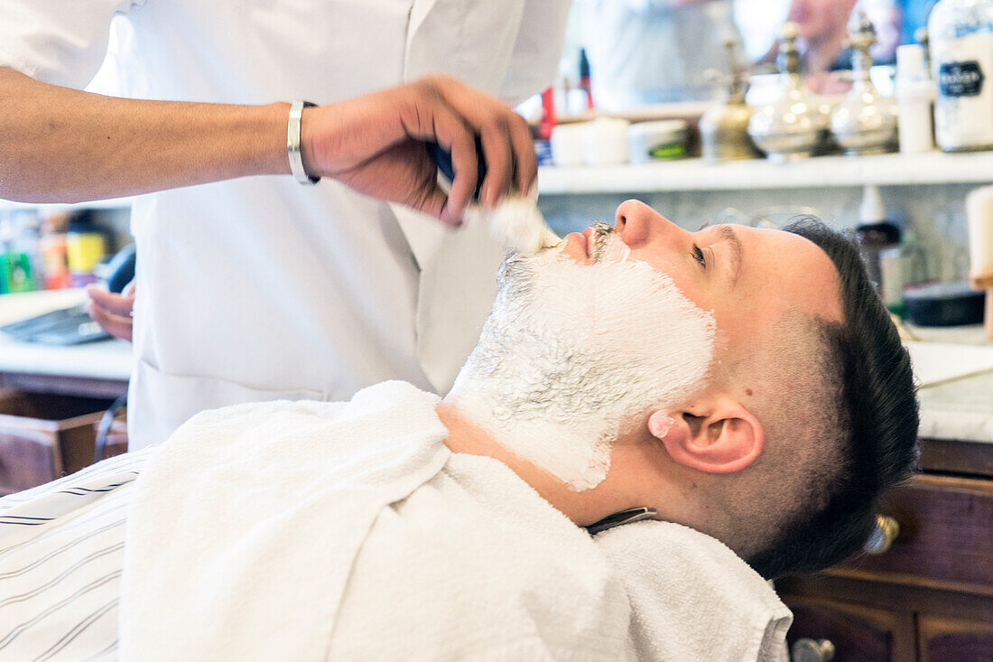 Professional Barber & Haircutter Shaving his Customer inside Schorem Barber Shop at Nieuwe Binnenweg, Rotterdam, Netherlands.